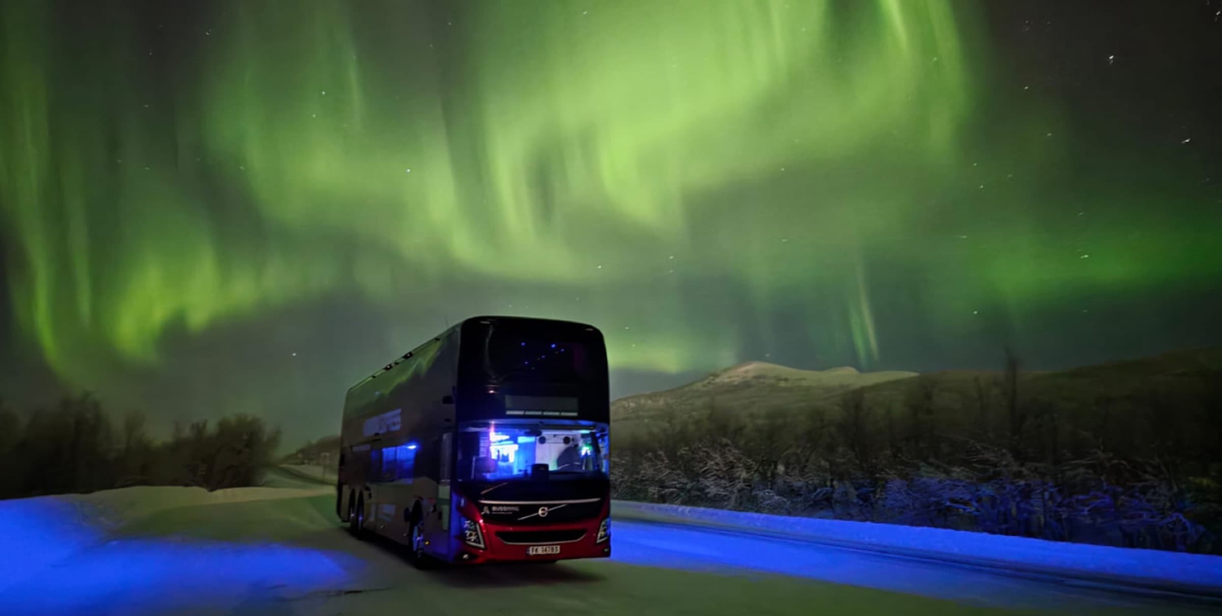 Best Arctic double-decker bus on a snowy road under the Northern Lights