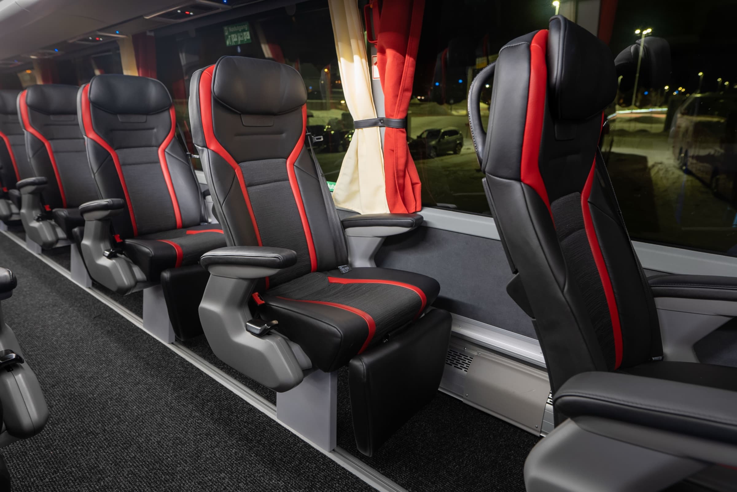 Sièges inclinables noirs et rouges à bord de l'Aurora Express